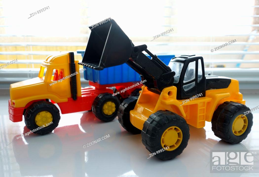 Stock Photo: Toy Wheel Loader and Toy Dump Truck Close up, Toy Industrial Vehicle, Plastic Wheel Loader Excavator for Earth Moving Works at Construction Site.