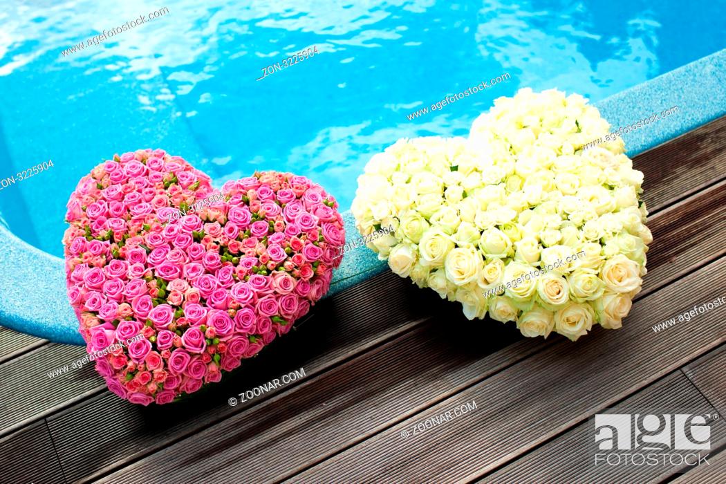 Stock Photo: Flower hearts near blue water of swimming pool.