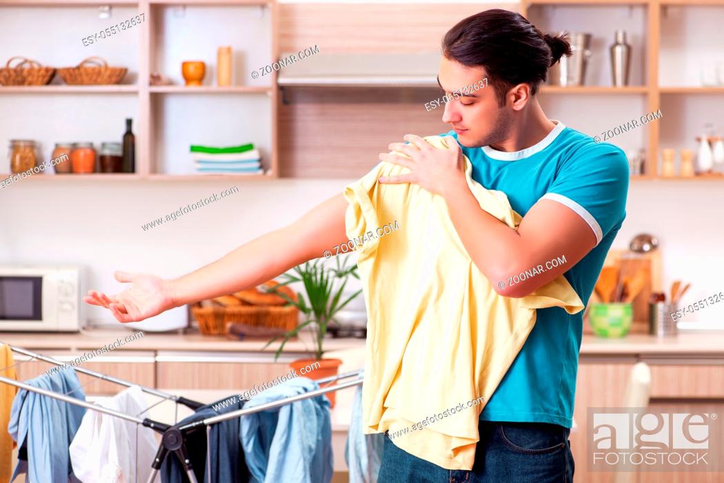 Imagen: Young man husband doing clothing ironing at home.