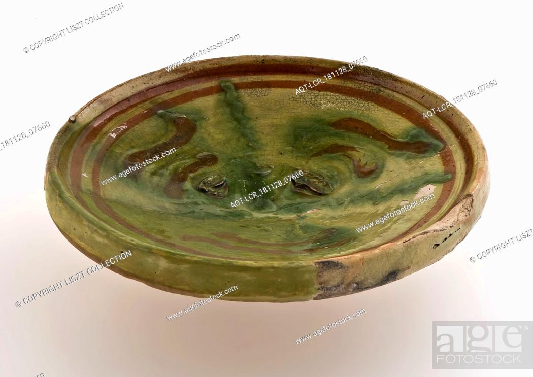 Stock Photo: Small earthenware plate on small stand, decorated with brown and green decor on yellow background, plate dish crockery holder soil find ceramic earthenware.