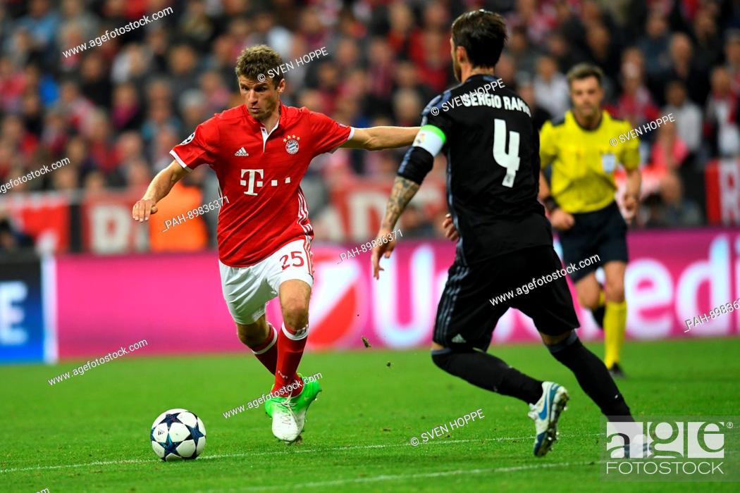 Stock Photo: Munich's Thomas Mueller (l) and Madrid's Sergio Ramos during the first leg of the Champions League quarter final match between Bayern Munich and Real Madrid in.