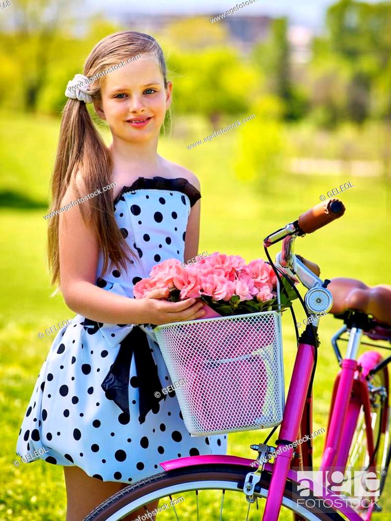 Bikes cycling girl. Child girl wearing white polka dots dress 