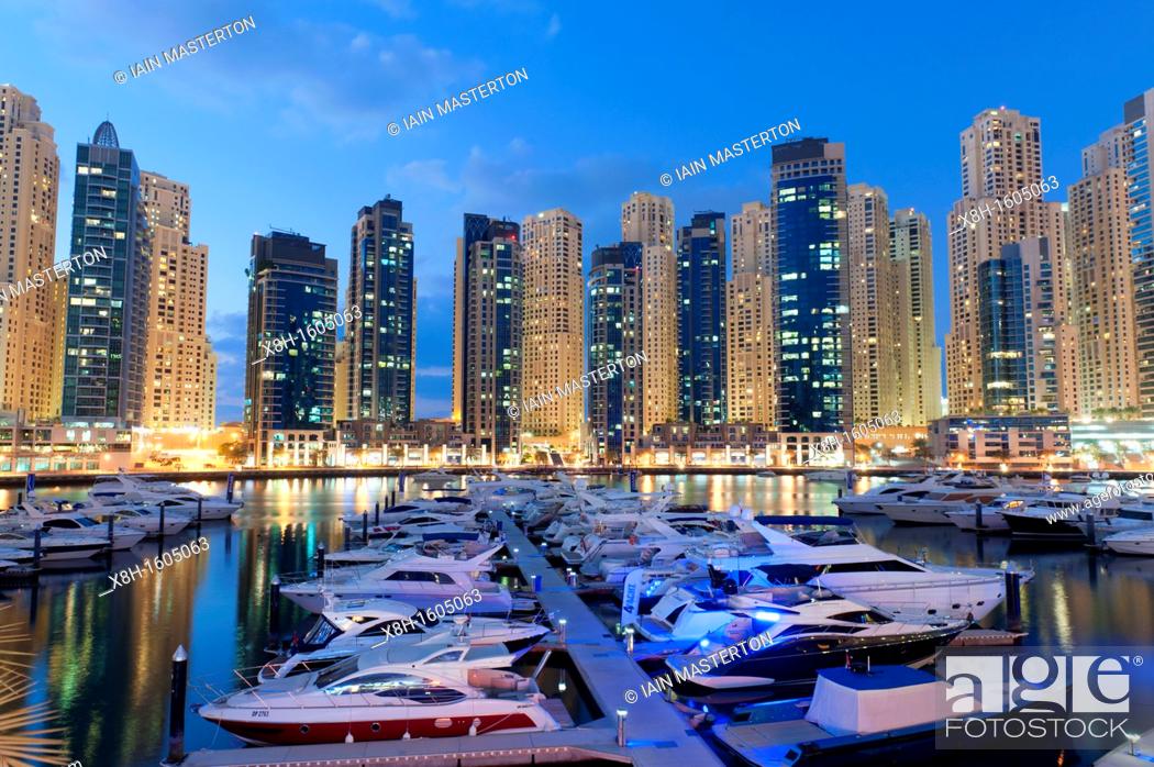 Stock Photo: Boats in harbour in the evening at Yacht Club Marina with apartment towers to rear in New Dubai in United Arab Emirates.