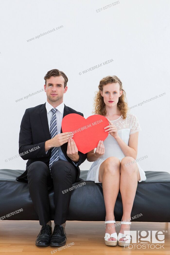 Photo de stock: Geeky couple sitting on couch.