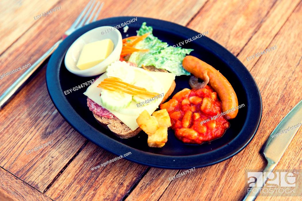 Stock Photo: cooking, asian kitchen and food concept - plate with sausage, sandwich and garnish on wooden table at restaurant.