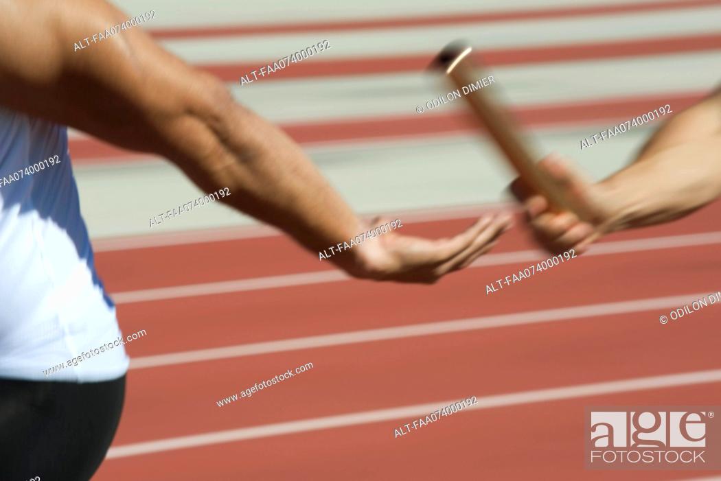 Stock Photo: Runners exchanging baton in relay race, cropped.