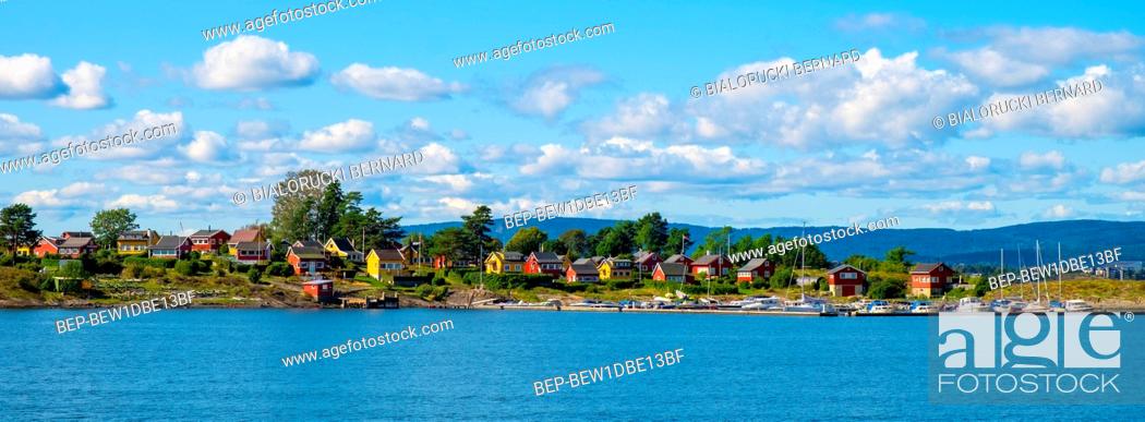 Stock Photo: Oslo, Ostlandet / Norway - 2019/09/02: Panoramic view of Nakholmen island on Oslofjord harbor with marina and summer cabin houses at shoreline in early autumn.