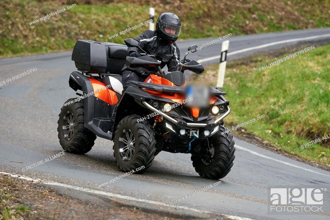 Stock Photo: 27 March 2021, Rhineland-Palatinate, Nievern: A quad rider is driving on a country road. According to accident expert Brockmann.
