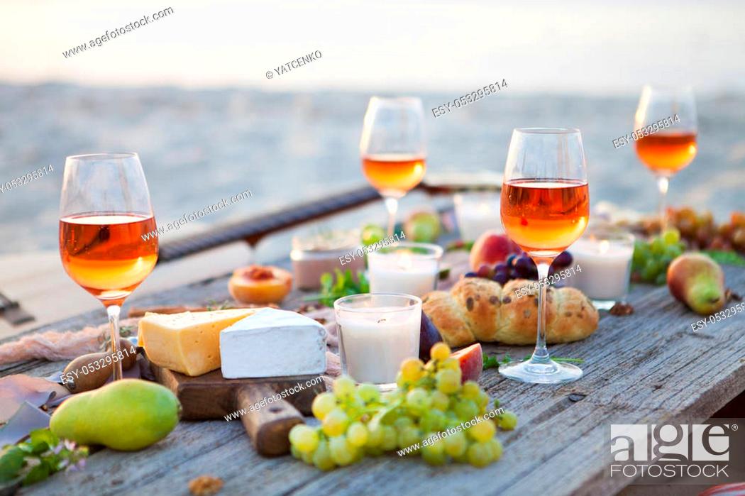 Imagen: Picnic on the beach at sunset in the style of boho, food and drink conception.