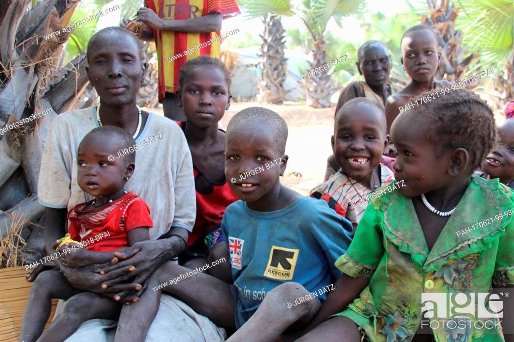 Stock Photo: Internally displaced Nyakume Wuor Gai sits together with her own children and neighbour's children in front of a shed on an island near Nyal at the federal.