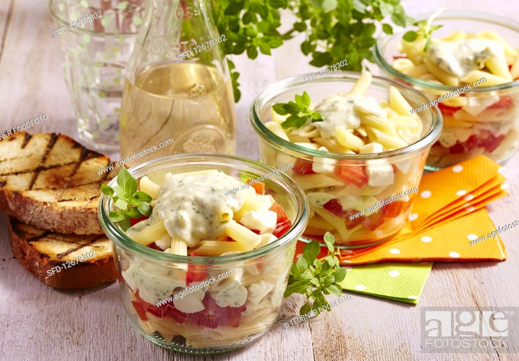 Stock Photo: Italian layered salad with pasta, vegetables, yoghurt dressing and mozzarella in preserving jars.