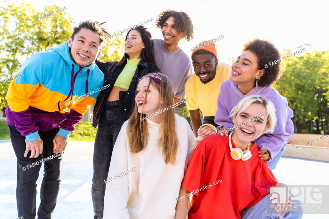 Stock Photo: Multicultural group of young friends bonding outdoors and having fun - Stylish cool teens gathering at urban skate park.