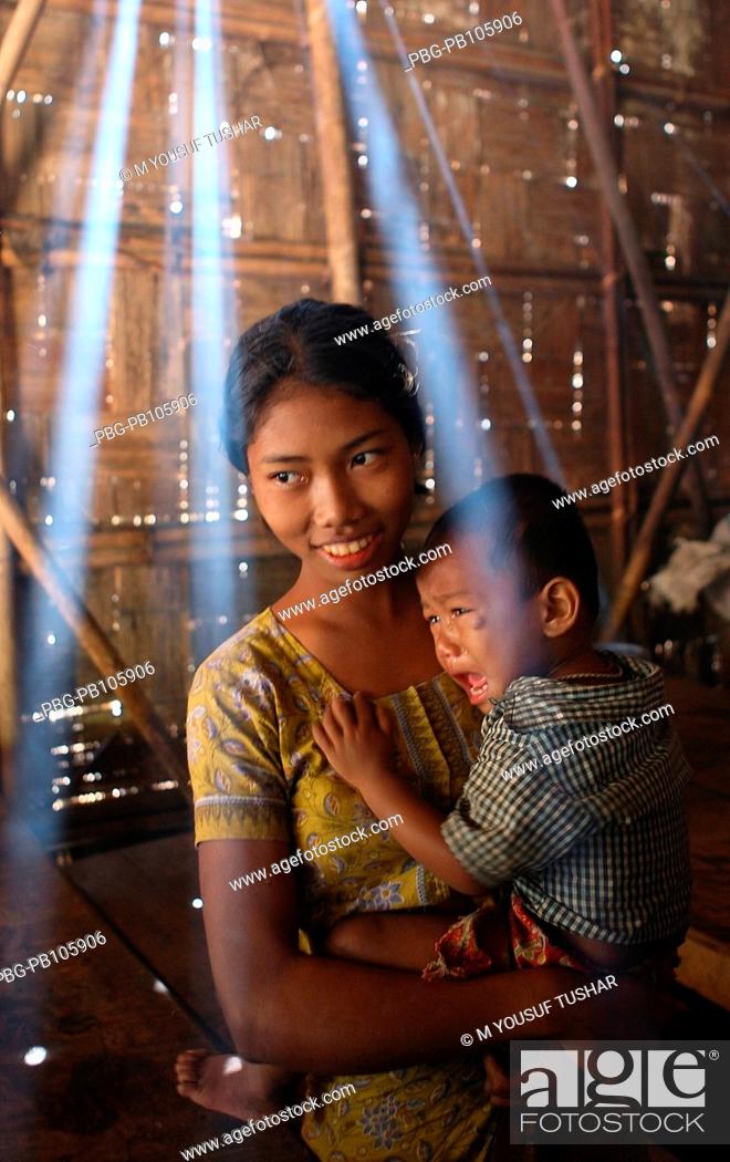 Stock Photo: An ethnic girl holding a child on her lap at Tindu Bandarban, Bangladesh December 2009.