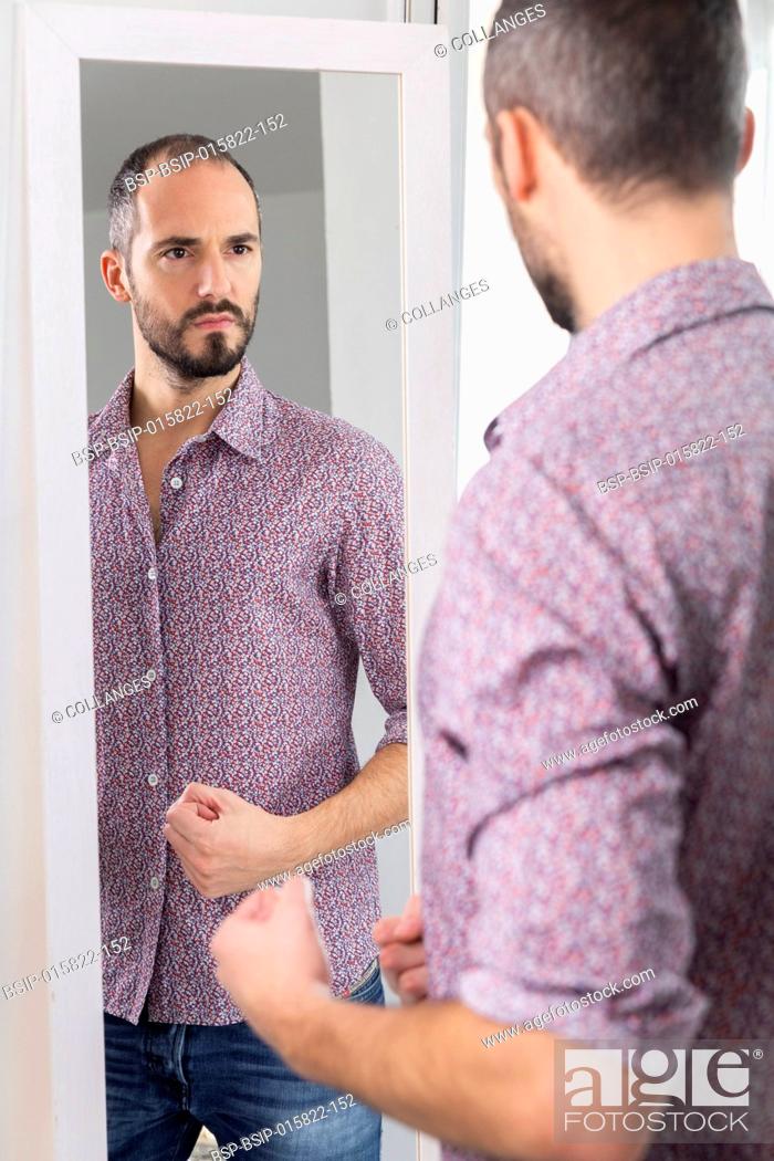 Stock Photo: A man looking in a mirror to give him self-confidence.