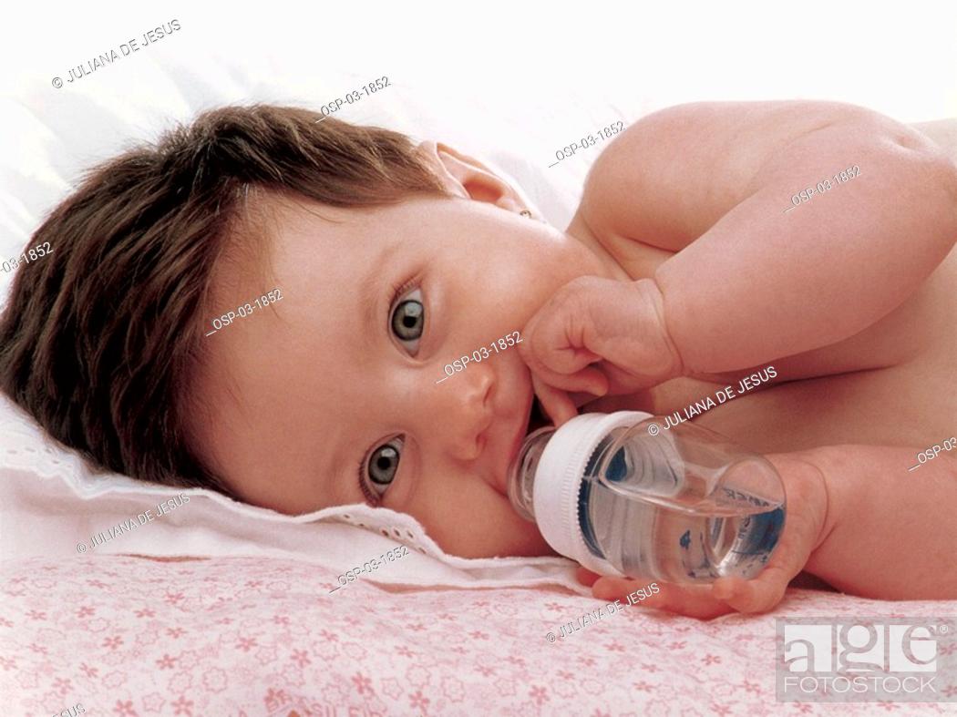 Stock Photo: People, Water, Happy, Smile, Young, Horizontal, Brunette, Child, Kid, Drinking, Indoors, Interior, Baby, Bed, Small, Concept, Bottle, Inside, Close, Idea, Laying, Feeder, Cheerful, Internal, Tot