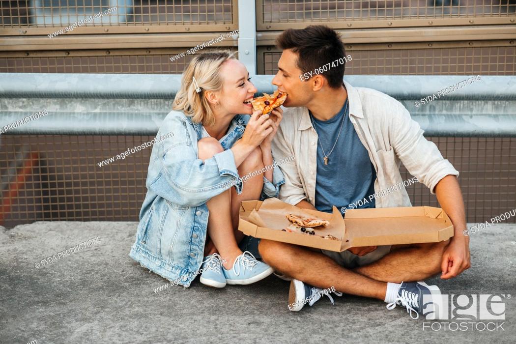 Stock Photo: happy couple eating pizza on city roof top parking.