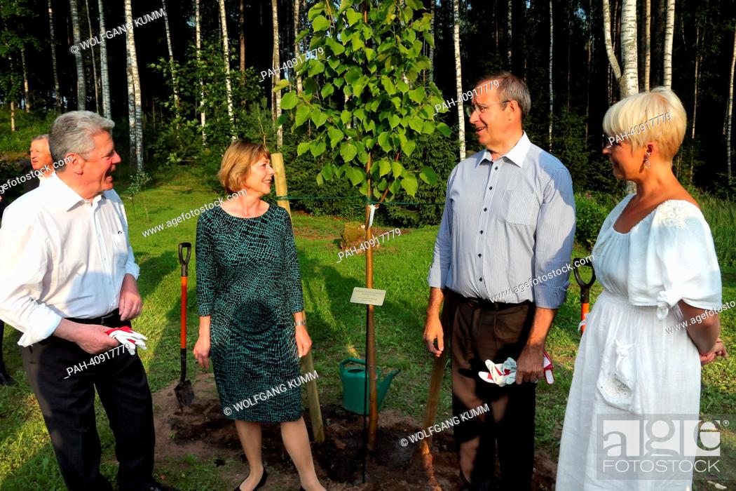 Stock Photo: German President Joachim Gauck (L-R), his partner Daniela Schadt, Estonian President Toomas Hendrik Ilves and his wife Evelin talk after having planted a lime.
