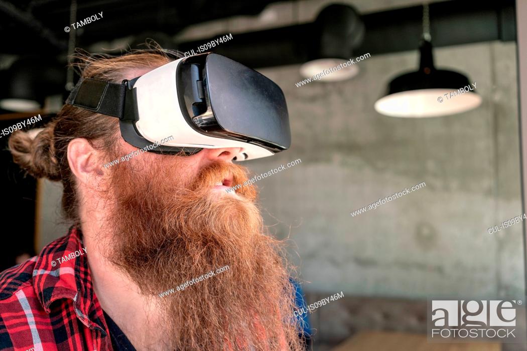 Stock Photo: Male hipster using VR goggles.