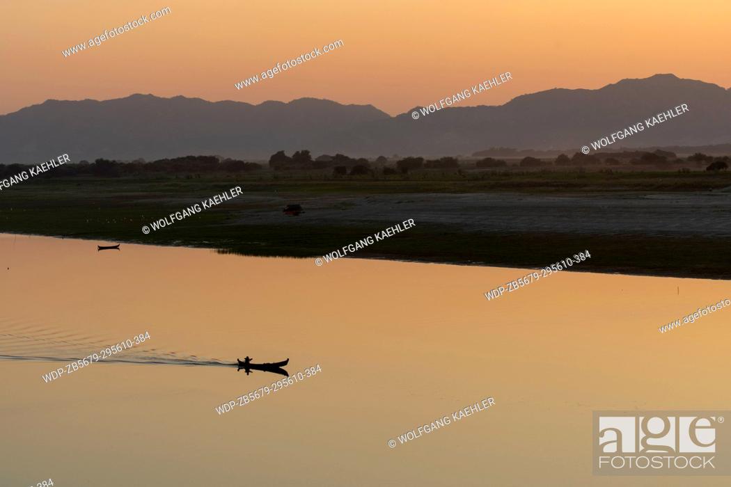 Stock Photo: A man in a boat on the Irrawaddy River (Ayeyarwady River) at sunset in Bagan, Myanmar.