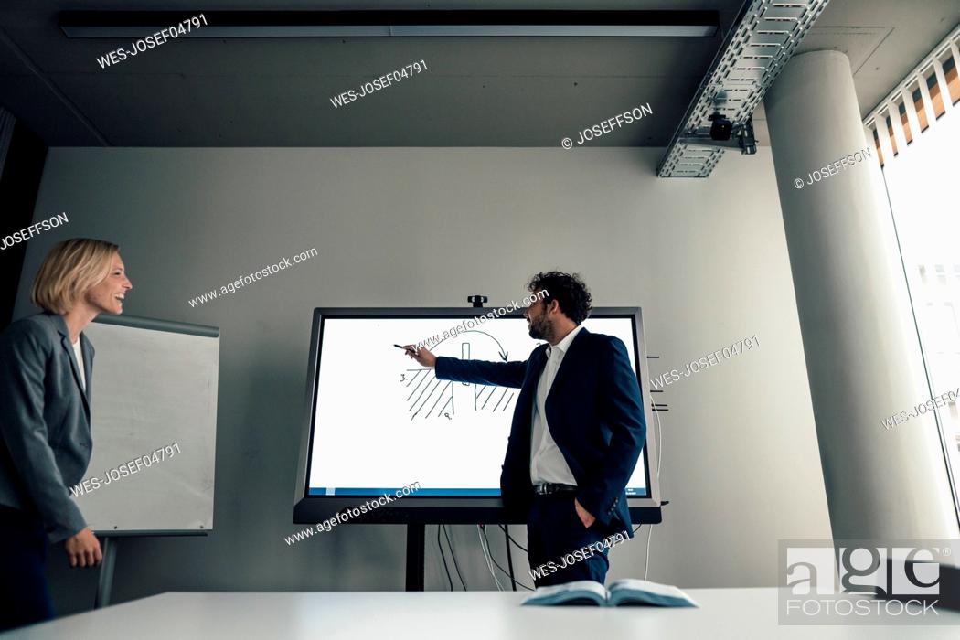 Stock Photo: Male entrepreneur explaining business plan to colleague in board room.