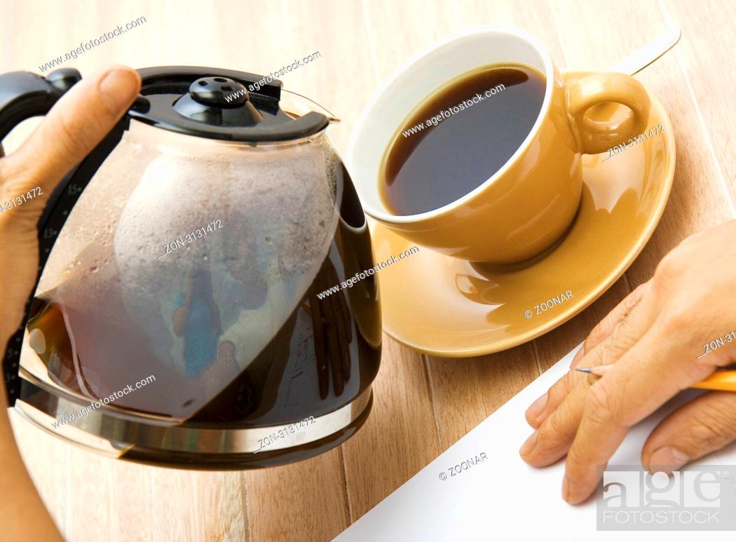 Stock Photo: A man doing some work pouring coffee in a cup.