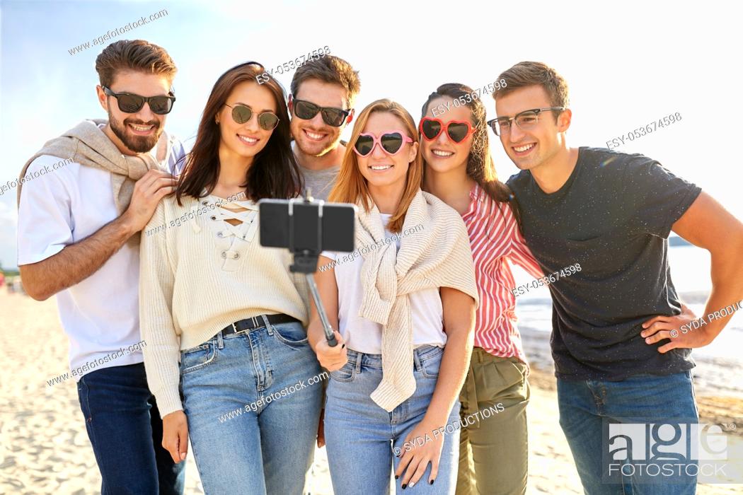 Stock Photo: happy friends taking selfie on summer beach.