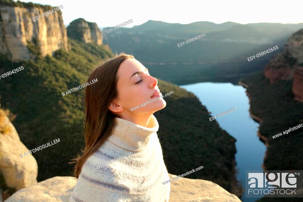 Stock Photo: Relaxed woman breathing fresh air in a cliff in the mountain.