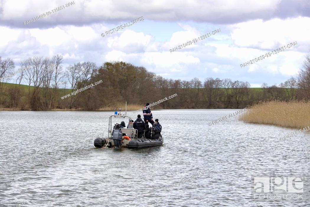 Stock Photo: 08 April 2021, Brandenburg, Flieth-Stegelitz/Gt Suckow: A rubber dinghy with divers of the Brandenburg police sails after the first dive on the Oberuckersee.