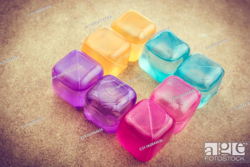 Stock Photo: Fake colorful ice cubes on a brown background.