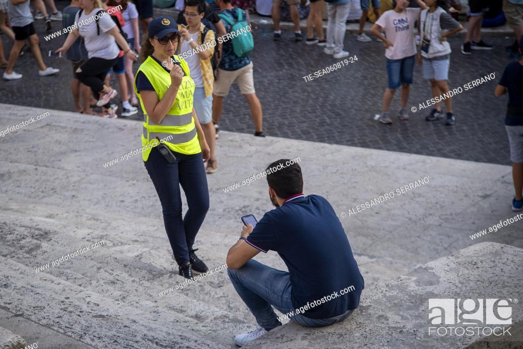 Stock Photo: Municipal Police invites people sitting on the steps of Trinita' dei Monti, in Piazza di Spagna to stand up, Rome, ITALY-06-08-2019.