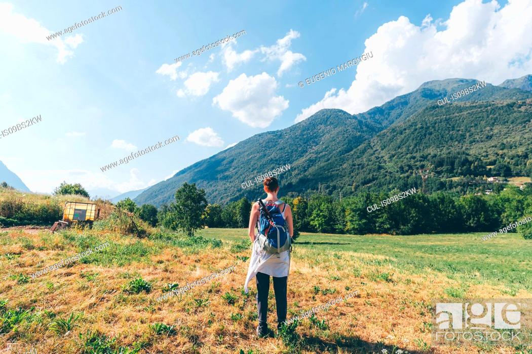 Stock Photo: Young female hiker looking towards mountains, rear view, Primaluna, Trentino-Alto Adige, Italy.