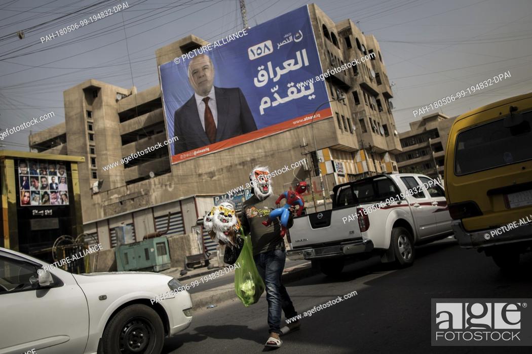 Stock Photo: A picture made available on 07 May 2018 shows a man selling masks backdropped by a campaign poster of Iraqi Prime Minister Haider al-Abadi in Baghdad, Iraq.