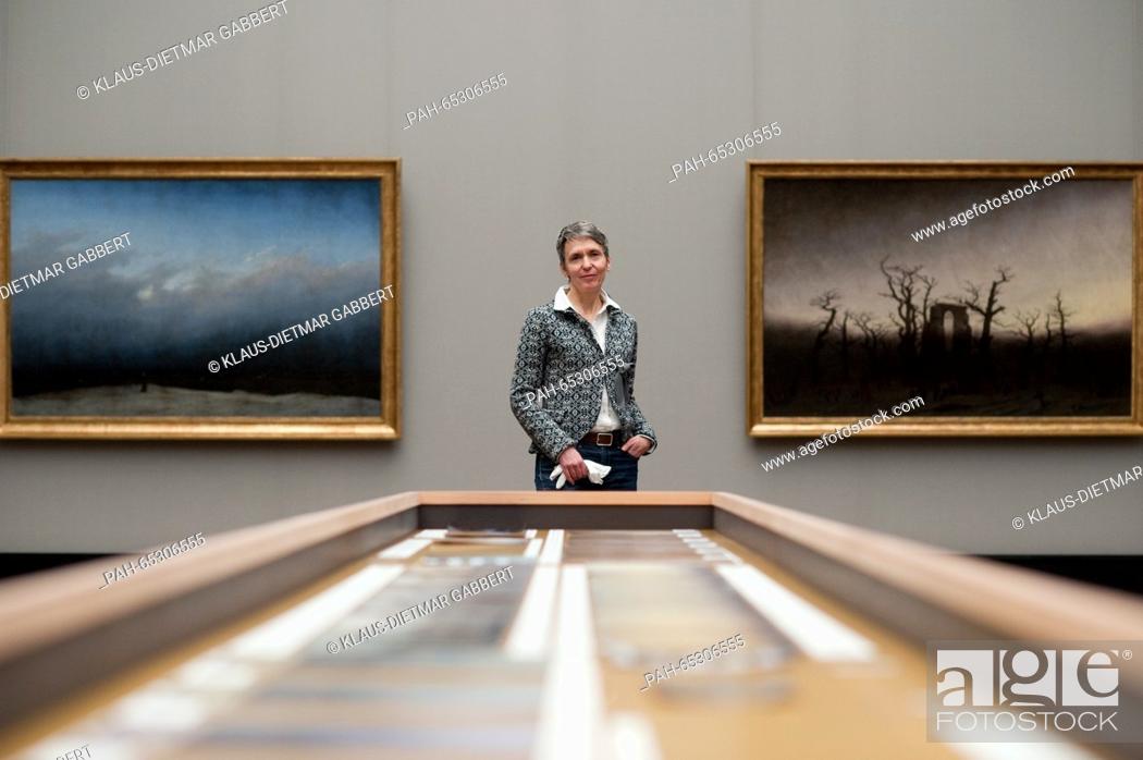Stock Photo: The leading conservator at the Alte Nationalgalerie Berlin, Kristina Moesl poses in front of the restored paintings 'The Monk by the Sea' (L, 1808-1810.
