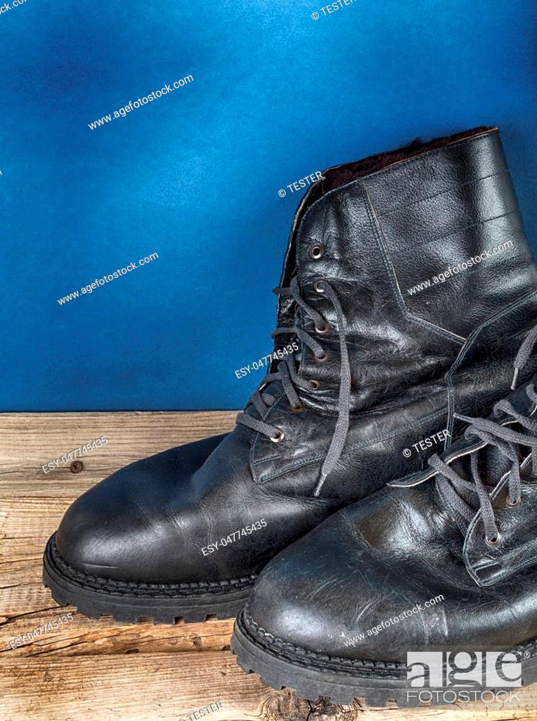 Stock Photo: Black army boots against the wall.