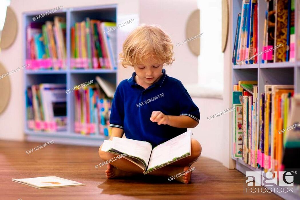 Stock Photo: Child in school library. Kids read books. Little boy reading and studying. Children at book store. Smart intelligent preschool kid choosing books to borrow.