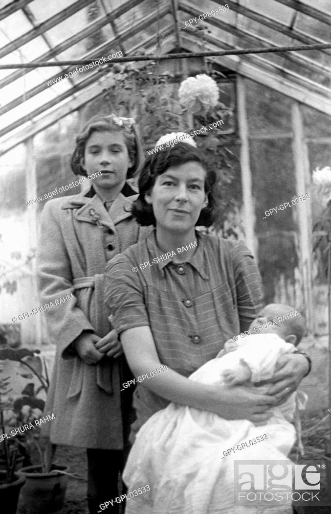Stock Photo: Mother with her children in a greenhouse.