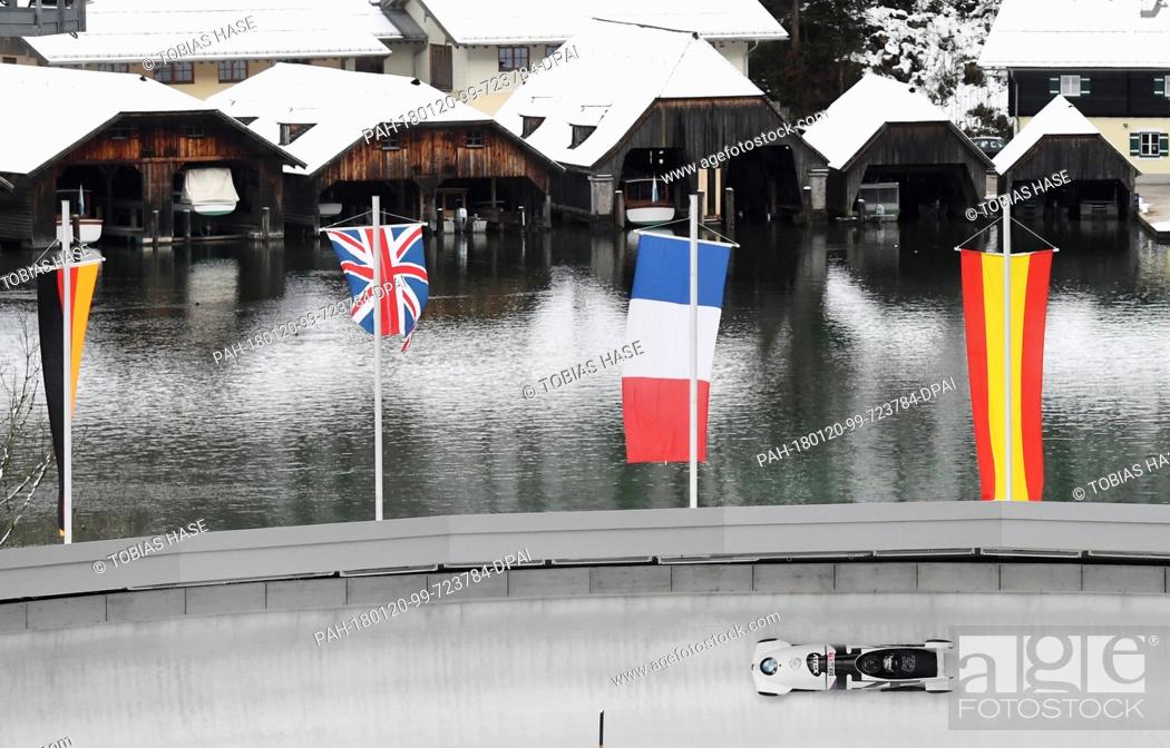Stock Photo: A bobsleigh team on echo-curve, with the boathouses on Koenigssee lake in the background, during the 2-man event at the Bobsleigh World Cup in Schoenau am.