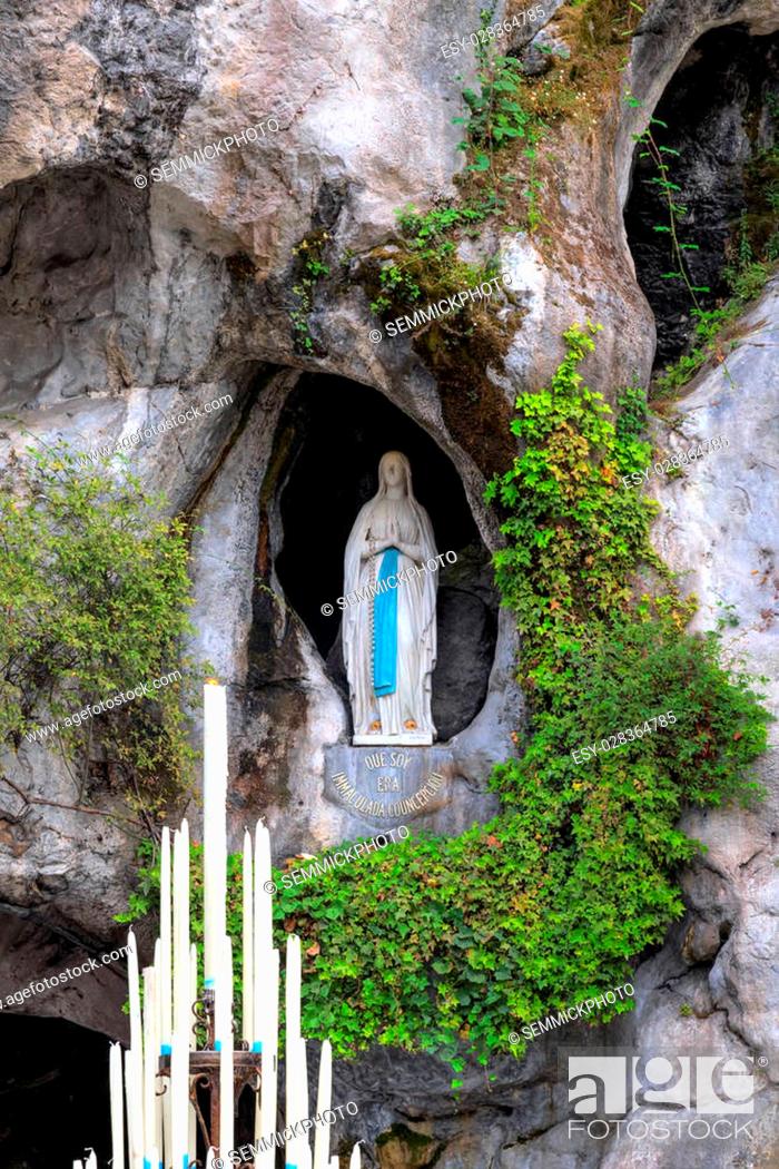Stock Photo: LOURDES, FRANCE - JULY 23, 2014: The rock cave at Massabielle with the statue of the Virgin Mary where Saint Bernadette Soubirous claimed to have witnessed.