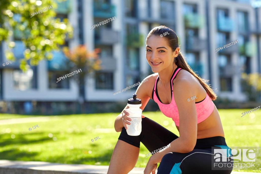 Stock Photo: Young woman holding water bottle.
