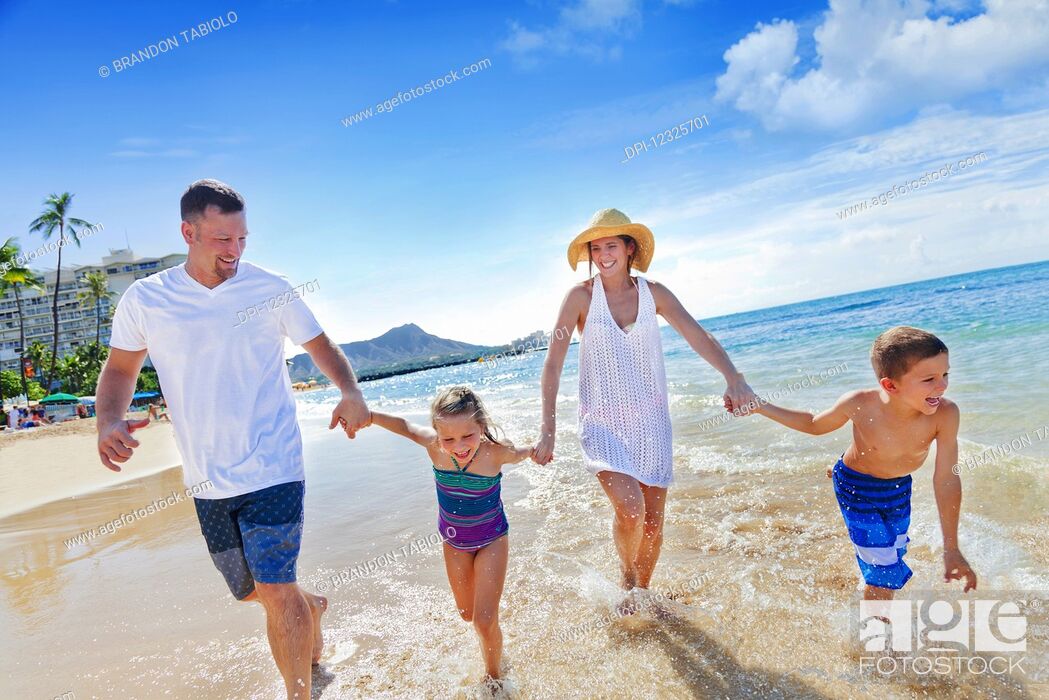 Stock Photo: Family of four enjoying a summer vacation in Waikiki Beach; Honolulu, Oahu, Hawaii, United States of America.