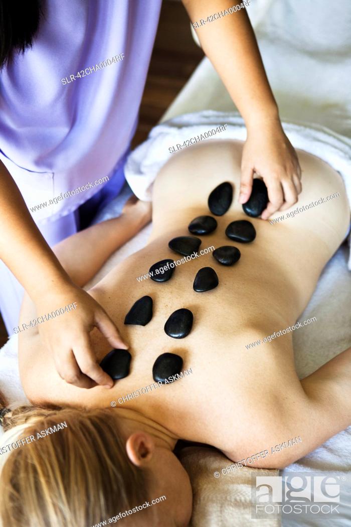 Stock Photo: Woman having hot stone massage in spa.