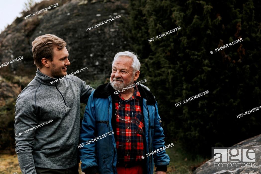 Photo de stock: Father with adult son looking at each other.