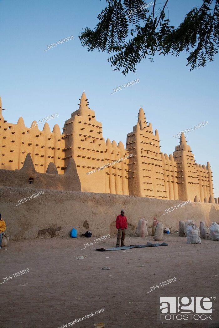 Stock Photo: Man Standing In Front Of The Grand Mosque At Djenne, Mali.