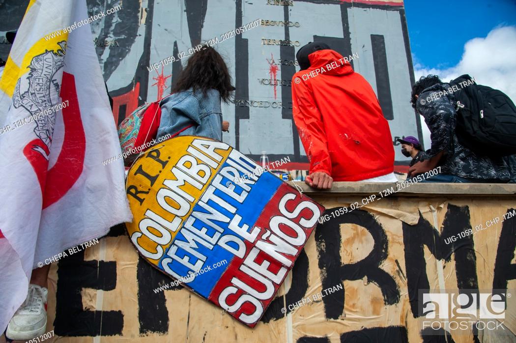 Stock Photo: A demonstrator holds a sign with the shape of a grave and the Colombian flag that reads ""R.I.P Colombia is a Cementrery of Dreams"" as Bogota.