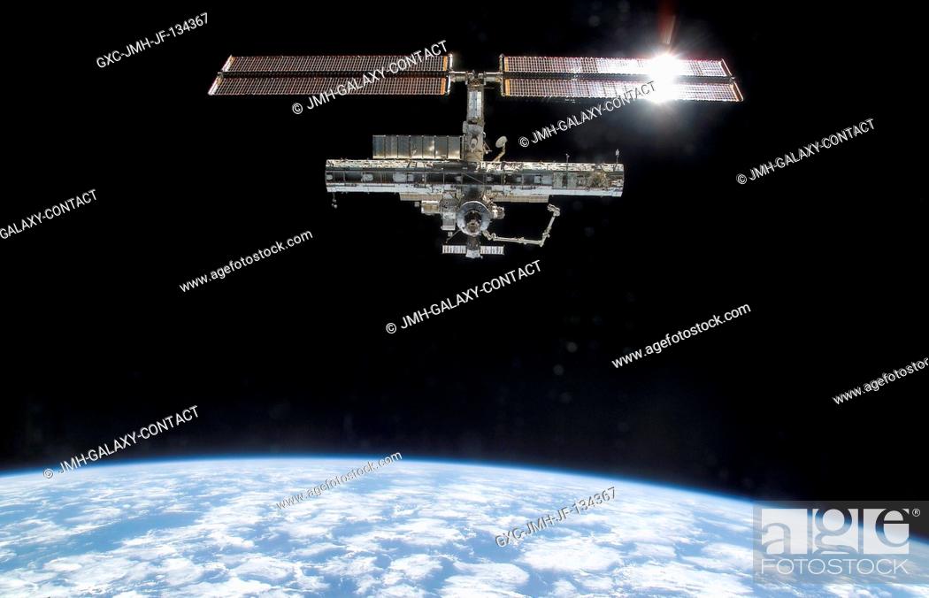 Stock Photo: Backdropped by the blackness of space and Earth's horizon, this full view of the International Space Station (ISS) was photographed by a crewmember on board the.