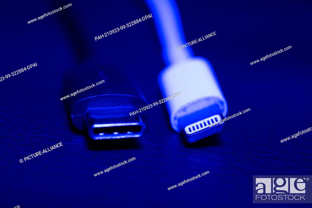 Stock Photo: 22 September 2021, Lower Saxony, Oldenburg: An Apple Lightning charging plug (r) can be seen next to a USB-C charging plug.