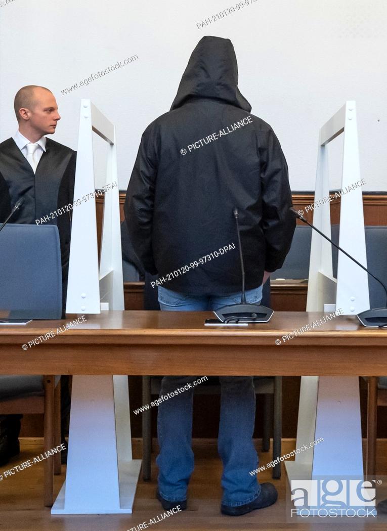 Stock Photo: 20 January 2021, North Rhine-Westphalia, Dortmund: The defendant stands at his place in the district court between Plexiglas panes to protect against infection.