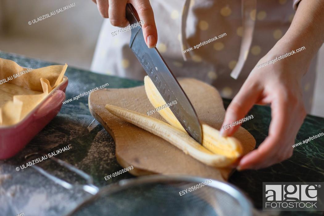 Stock Photo: The girl's hands close-up cut a peeled banana along.