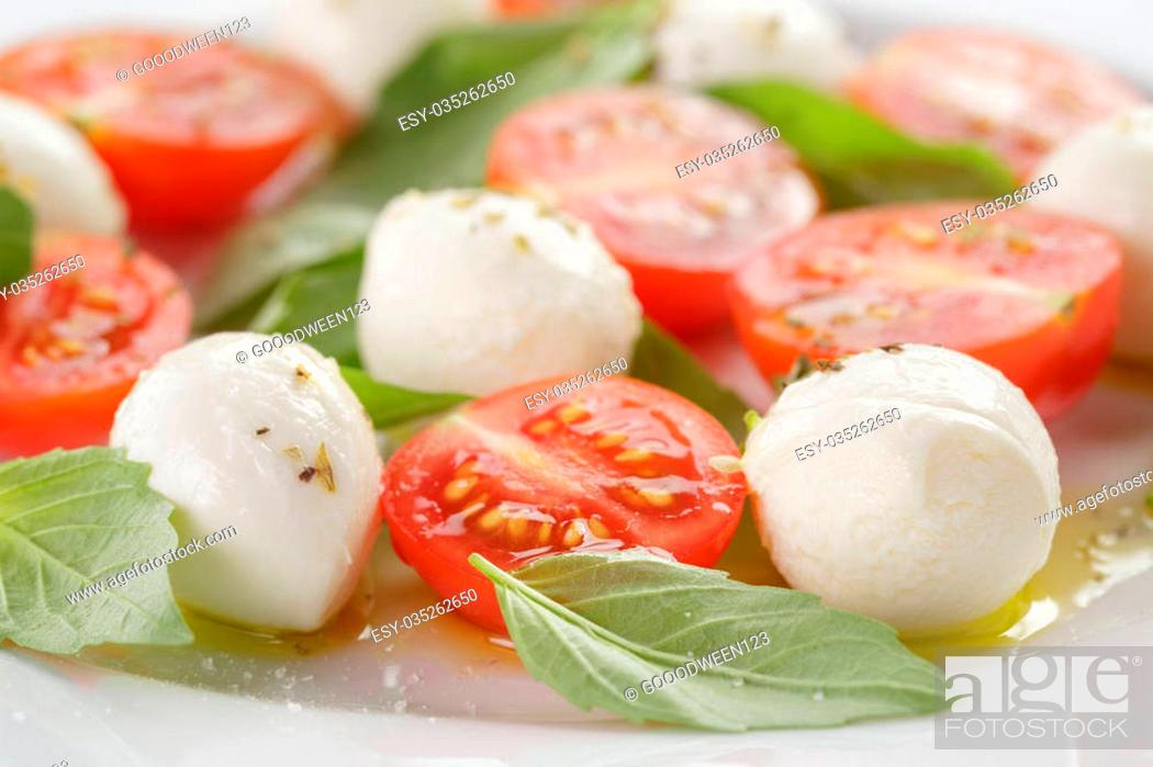 Stock Photo: caprese salad with mini mozzarella balls and tomatoes, closeup photo.