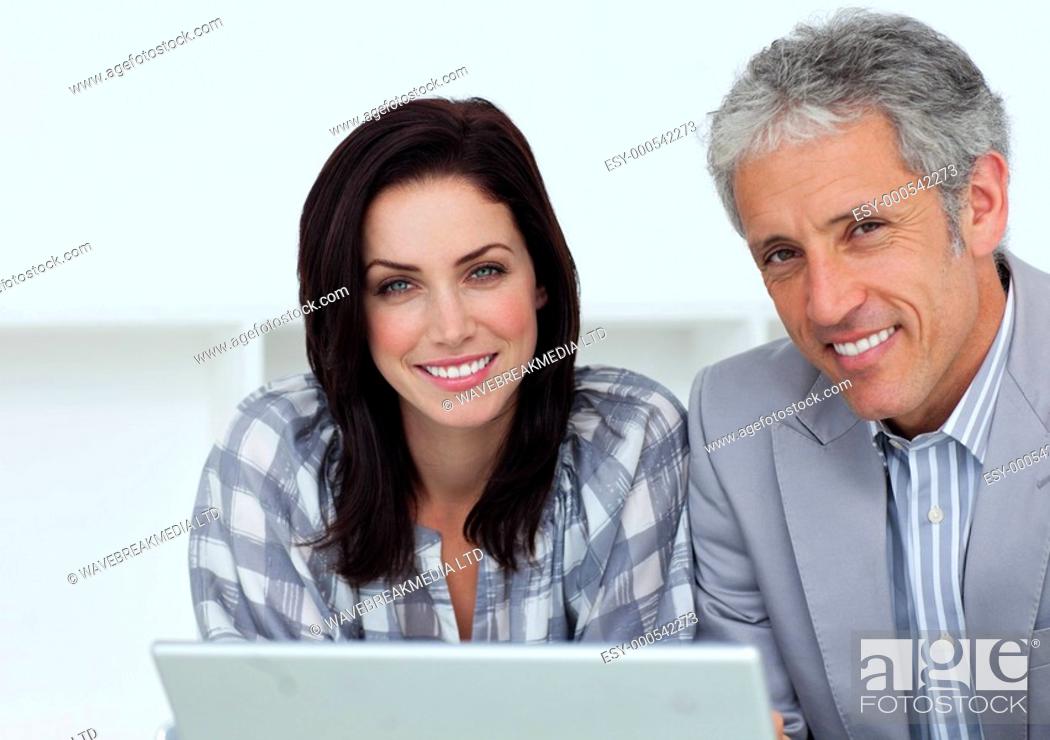 Stock Photo: Cheerful business people working at a computer in an office.